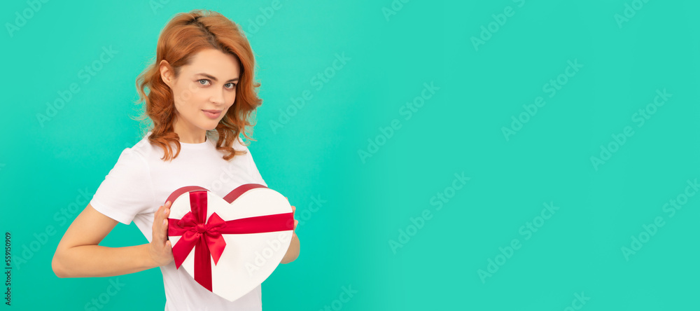 Woman isolated face portrait, banner with mock up copyspace. smiling girl hold heart gift box on blue background. Woman isolated face portrait, banner with mock up copyspace. smiling girl hold heart gift box on blue background.