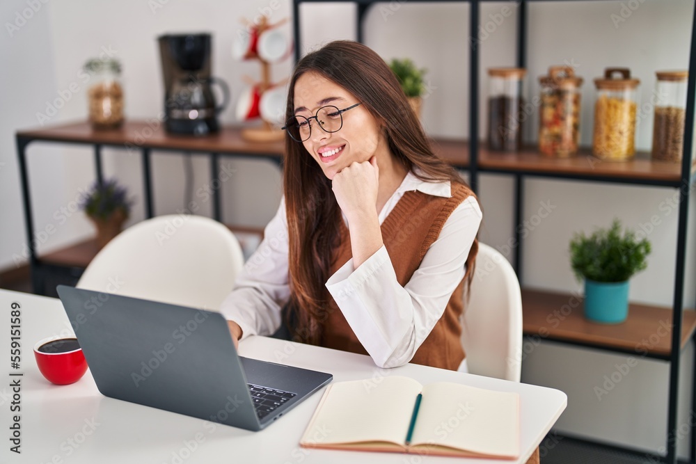 Young beautiful hispanic woman sitting on table studying at home Young beautiful hispanic woman sitting on table studying at home