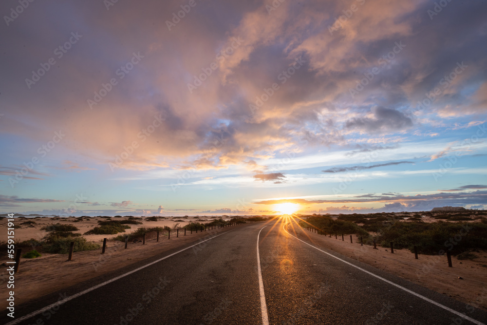Sunrise over the sand dunes and a dune road. Light drifts from cars, Corralejo National Park in the morning, Las Palmas Province, Fuerteventura, Canary Islands, Spain