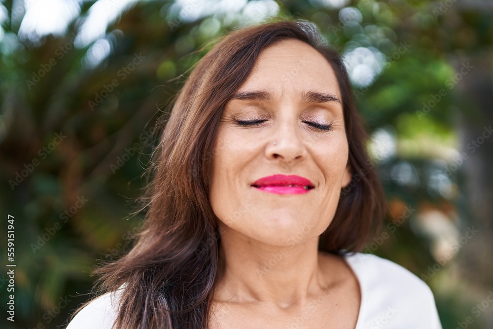 Young beautiful hispanic woman breathing with closed eyes at park Young beautiful hispanic woman breathing with closed eyes at park