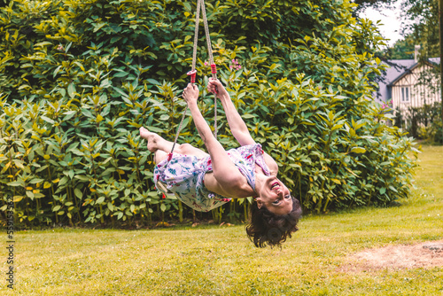 pretty middle aged dark haired woman swinging on childrens swings
