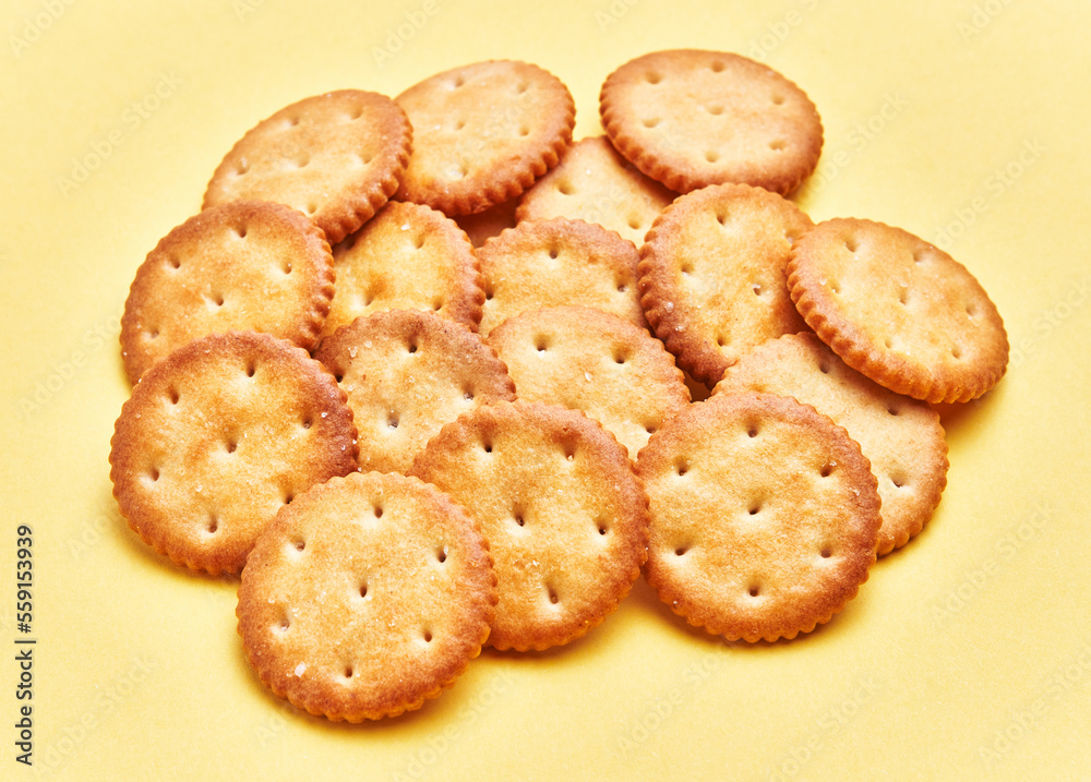 Delicious group of salty biscuits over isolated yellow background Delicious group of salty biscuits over isolated yellow background