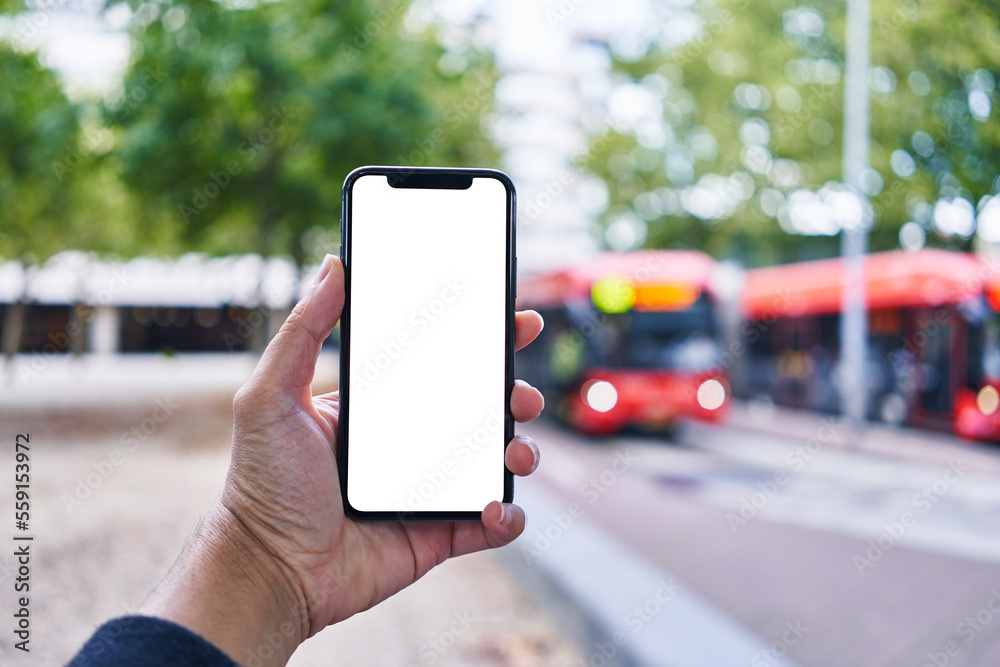 Man holding smartphone showing white blank screen at bus stop Man holding smartphone showing white blank screen at bus stop
