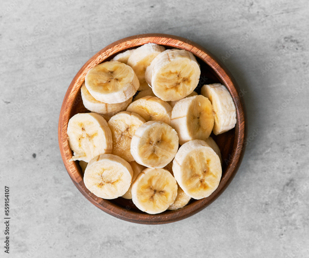 Photo of banana slices in a bowl on a concrete surface Photo of banana slices in a bowl on a concrete surface