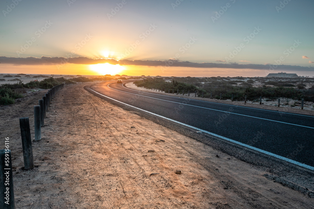 Beautiful morning on a road through the dunes. Sunrise over a road with clouds. Corralejo National Park, Canary Islands, Spain