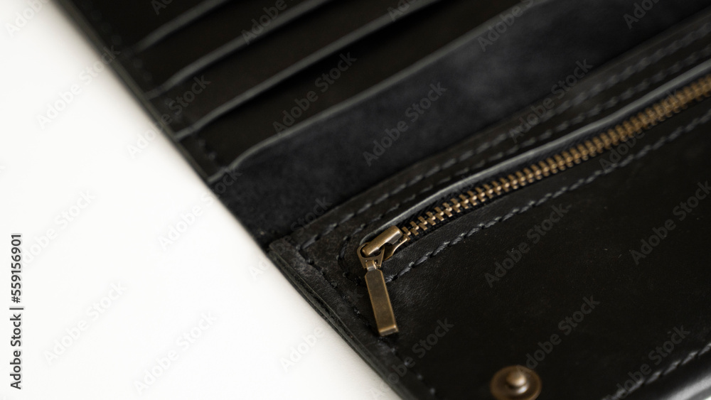 Details of open handmade brown man's genuine leather wallet with zipper on a button for banknotes and credit cards isolated on white background. Details of open handmade brown man's genuine leather wallet with zipper on a button for banknotes and credit cards isolated on white background.