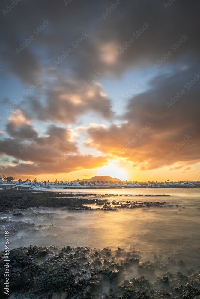 Sunset at Playa Vista Lobos, long exposure at the sea, lava beach Corralejo, Canary Islands, Spain Sunset at Playa Vista Lobos, long exposure at the sea, lava beach Corralejo, Canary Islands, Spain