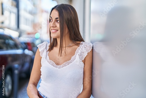 Young beautiful hispanic woman smiling confident looking to the side at street