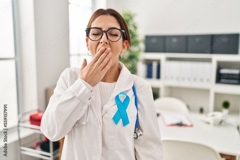 Young brunette doctor woman wearing stethoscope at the clinic bored yawning tired covering mouth with hand. restless and sleepiness. Young brunette doctor woman wearing stethoscope at the clinic bored yawning tired covering mouth with hand. restless and sleepiness.
