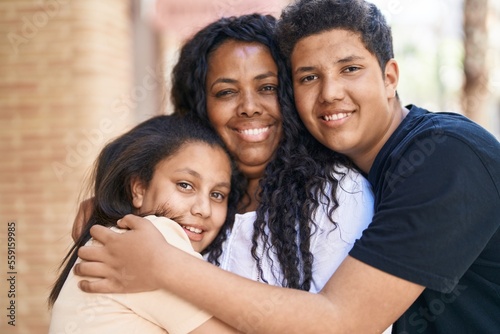 African american family hugging each other at street