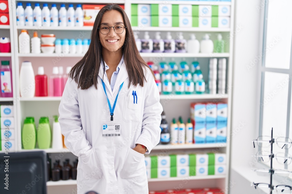 Young beautiful hispanic woman pharmacist smiling confident standing at pharmacy