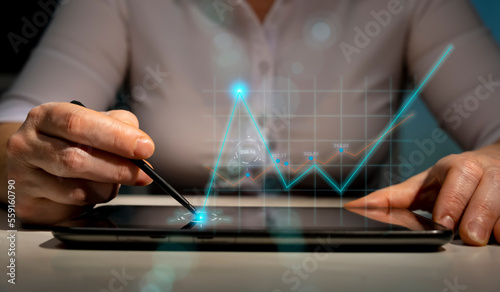 Business woman using tablet with holographic financial graph, analysis, planning, development growth strategy