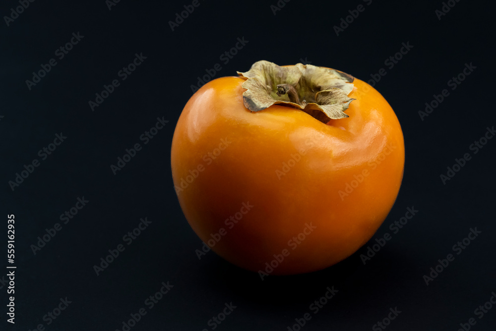 Natural and Organic Kaki fruit (Turkish: persimmon) on black background Natural and Organic Kaki fruit (Turkish: persimmon) on black background