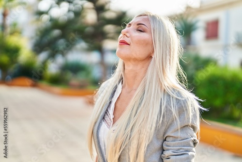 Young blonde woman smiling confident breathing at park © Krakenimages.com