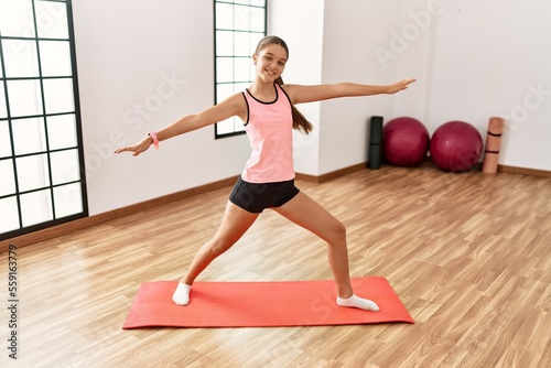 Adorable girl smiling confident doing yoga at sport center
