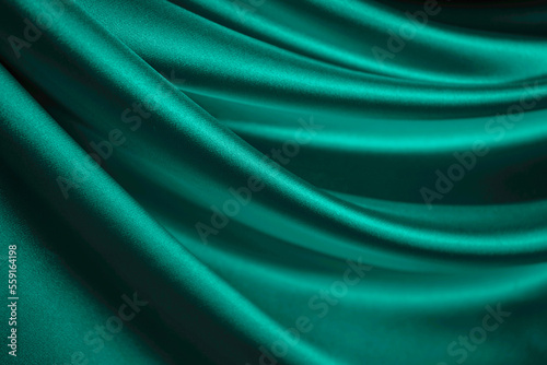 Blue green silk satin. Emerald curtain. Drapery. Shiny fabric. Elegant background for design. Liquid, wave, ripple effect. Beautiful soft folds. Christmas, Valentine.
