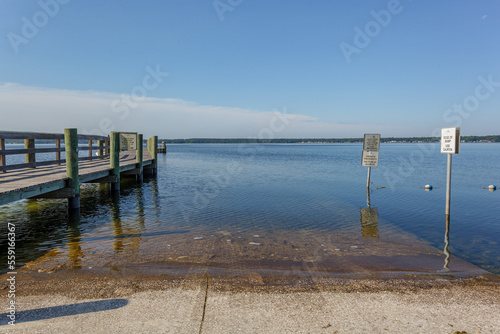 Dock leading out to a large blue lake with a clear blue sky above