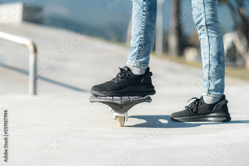 Legs on waveboard close up, Girl riding on casterboard with two wheels, modern street skate sports of teenagers, ripstick for balance ride. photo