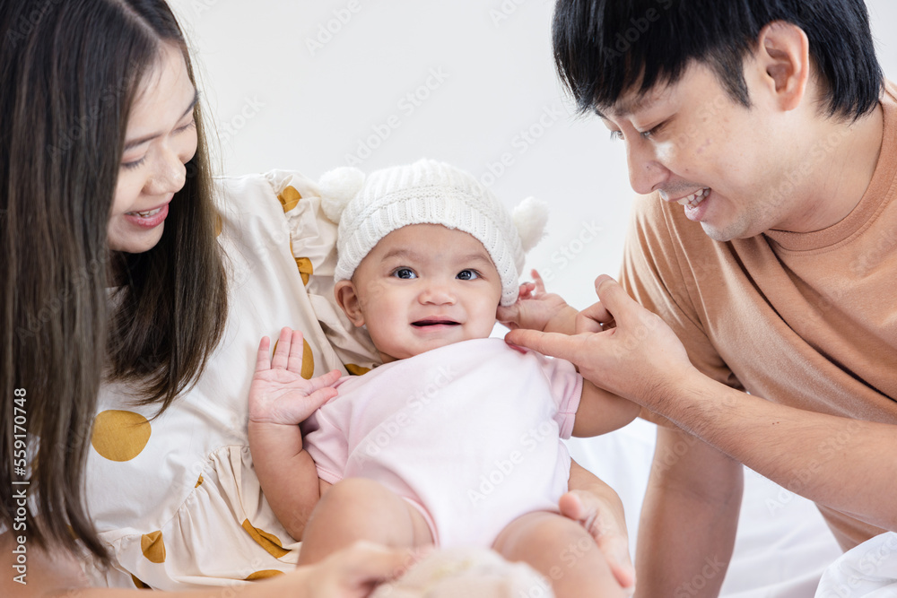 Toddlers are feeling safe and happy with their parents' care in bed at home. Asian family takes care of their children's health with love. Young children are learning to develop their brains. Toddlers are feeling safe and happy with their parents' care in bed at home. Asian family takes care of their children's health with love. Young children are learning to develop their brains.