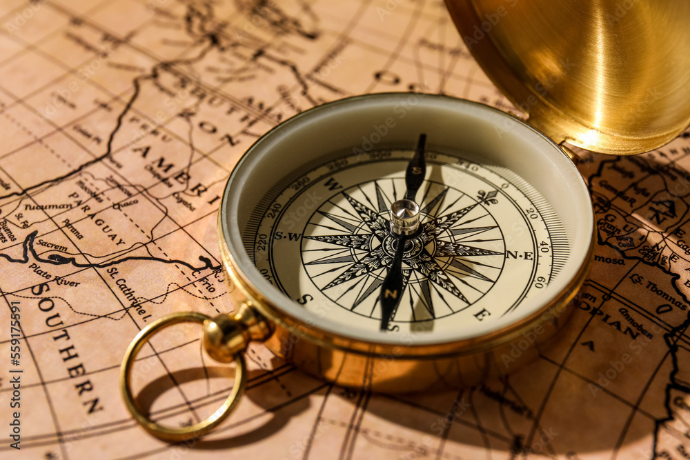 Vintage golden compass on world map, closeup