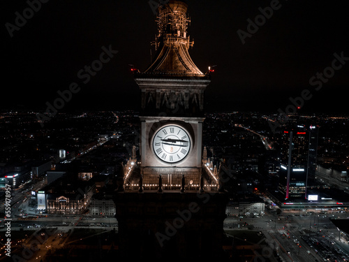 Aerial night view of the Palace of Culture and Science near downtown business skyscrapers in the city center.