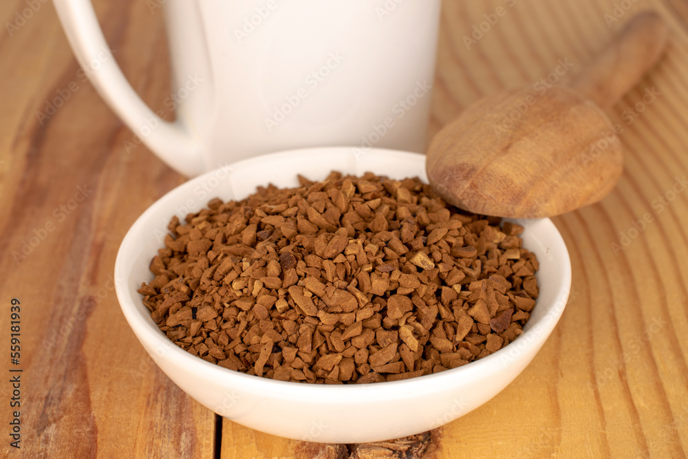 Fragrant instant coffee in a white ceramic saucer on a wooden table. Fragrant instant coffee in a white ceramic saucer on a wooden table.