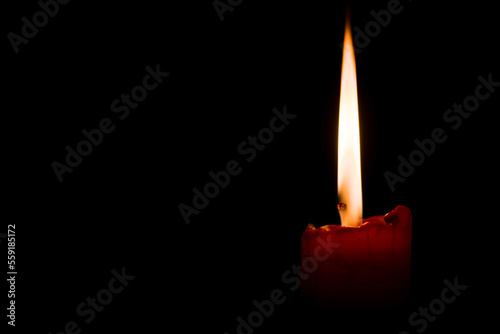 Close Up burning candle in the dark, black background
