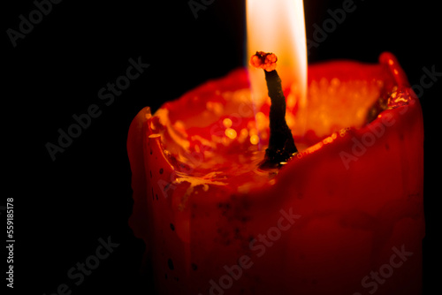 Close Up burning candle in the dark, black background