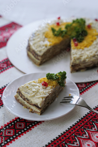 Homemade layered liver cake. Traditional Ukrainian food on the table with embroidered tablecloth.