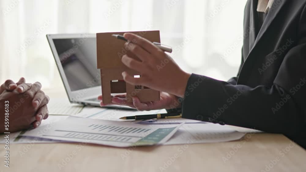 Close up of business's hands selling and signing agreement paperwork for loan financial to buying the house properties then give a key to customers.