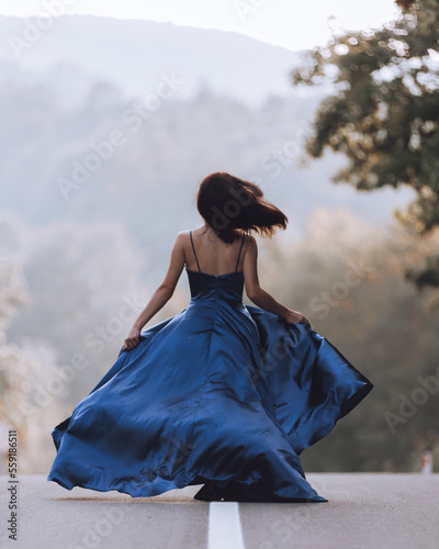Woman in blue dress on asphalt