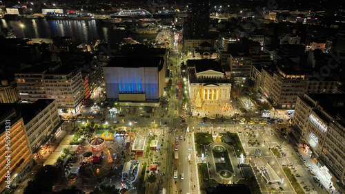 Aerial drone night shot of famous neoclassic Municipal Theatre of Piraeus and recently renovated main square illuminated during Christmas period, Attica, Greece