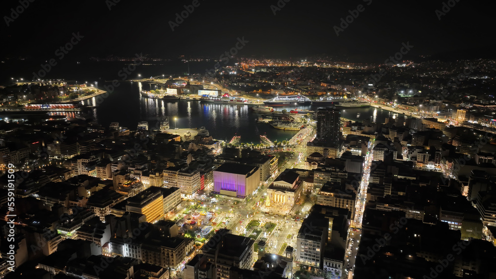 Aerial drone night shot of famous neoclassic Municipal Theatre of Piraeus and recently renovated main square illuminated during Christmas period, Attica, Greece