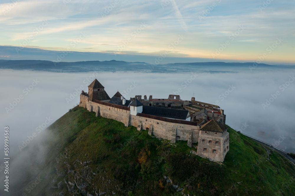 Aerial view about castle of Sumeg with foggy sunrise at the background.