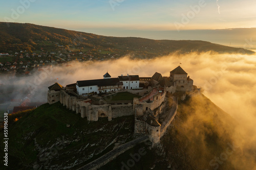 Aerial view about castle of Sumeg with foggy sunrise at the background. photo