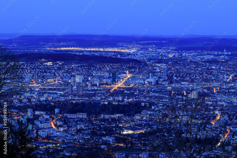 Swiss city Zürich in blue hours with the Zurich Airport at the far left above viewd from the Uetliberg