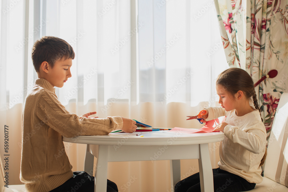 children draw with pencils and make crafts from colored paper children draw with pencils and make crafts from colored paper