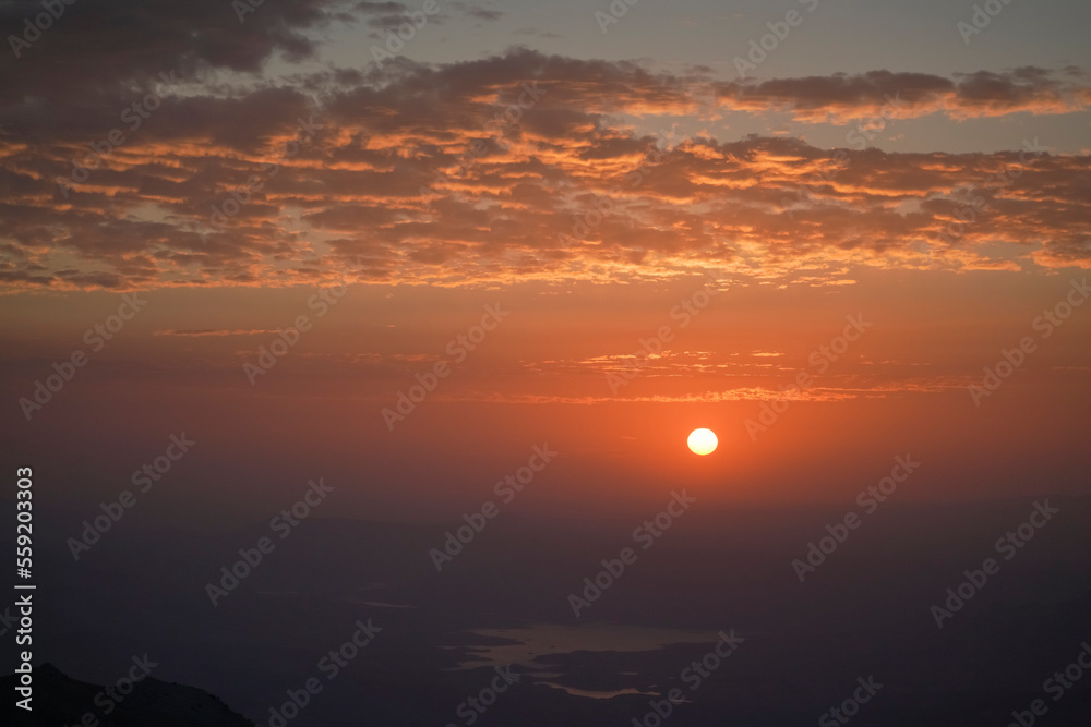 Sunrise view of mount nemrut, the sun cames up from east behind the mountains and lake and colorful clouds make the view better
