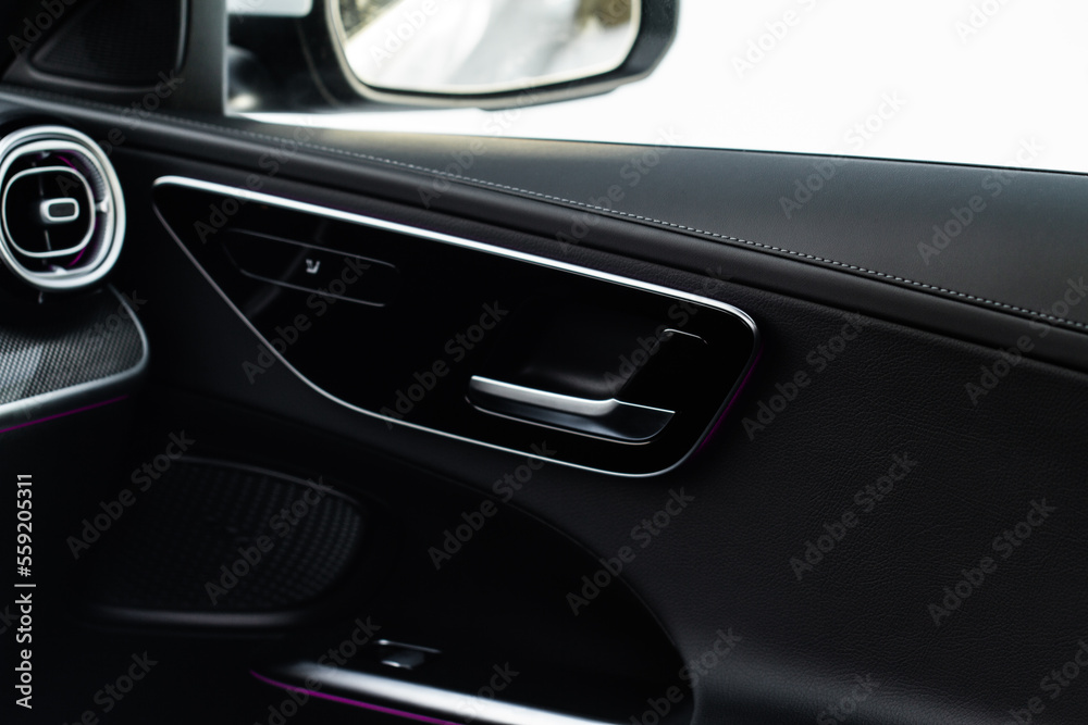 Modern car interior door handle close up. Metallic Car door opener handle inside.