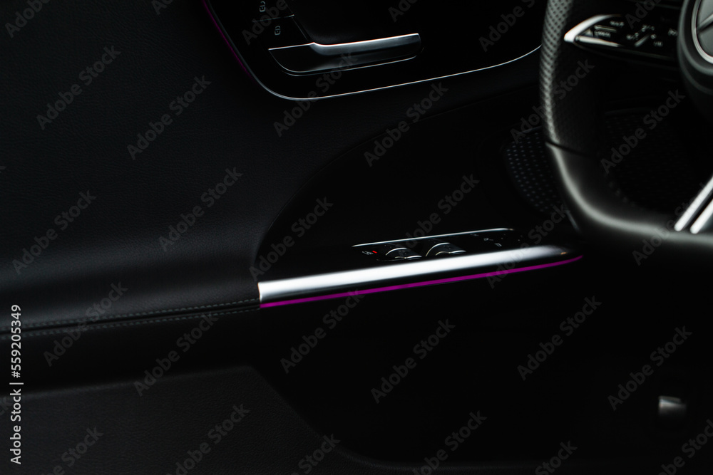 Close up view of button controlling window in modern car interior. Vehicle interior detail. Door handle with windows controls Close up view of button controlling window in modern car interior. Vehicle interior detail. Door handle with windows controls