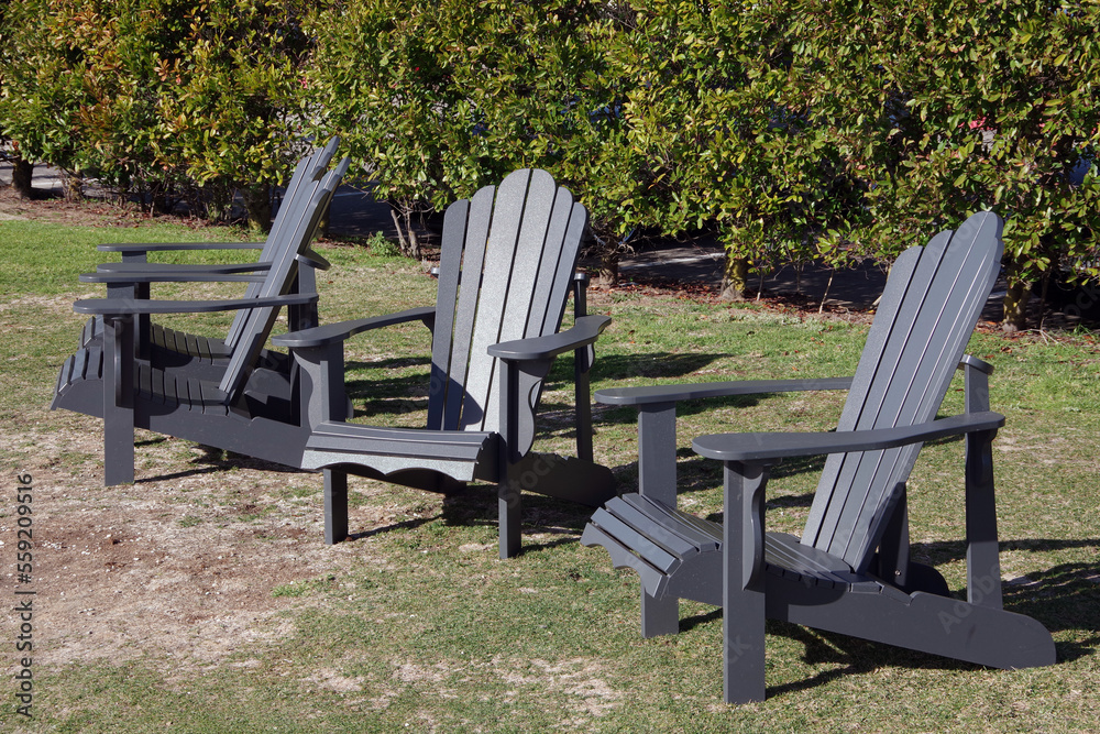 Gray Adirondack chairs outdoors in the garden Gray Adirondack chairs outdoors in the garden