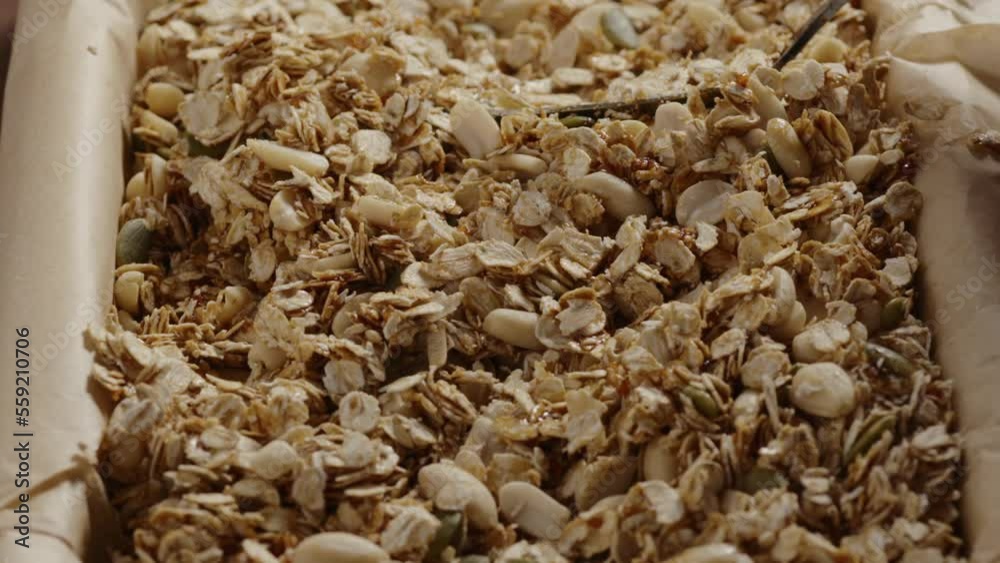 Slow motion making homemade granola mixing oats with nuts and seeds Slow motion making homemade granola mixing oats with nuts and seeds