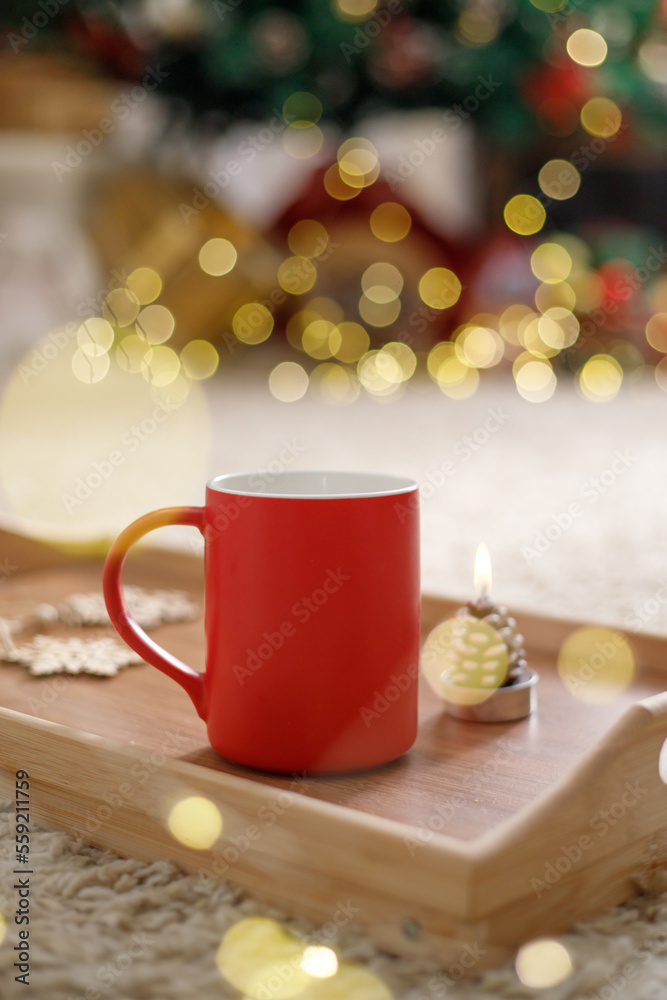 Red mug on the background of the xmas tree bokeh lights. Christmas time, New Year holiday. Red mug on the background of the xmas tree bokeh lights. Christmas time, New Year holiday.