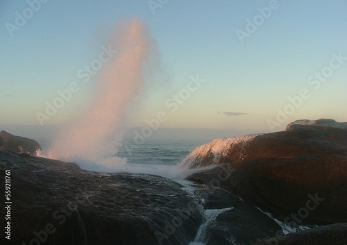 wave crashing over rocks at dusk