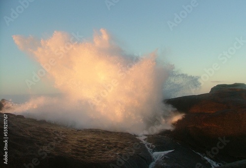 wave crashing over rocks at dusk