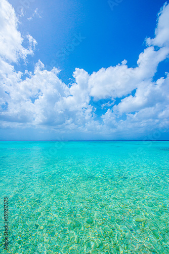 blue sky with scattered clouds and crystal clear turquoise ocean water