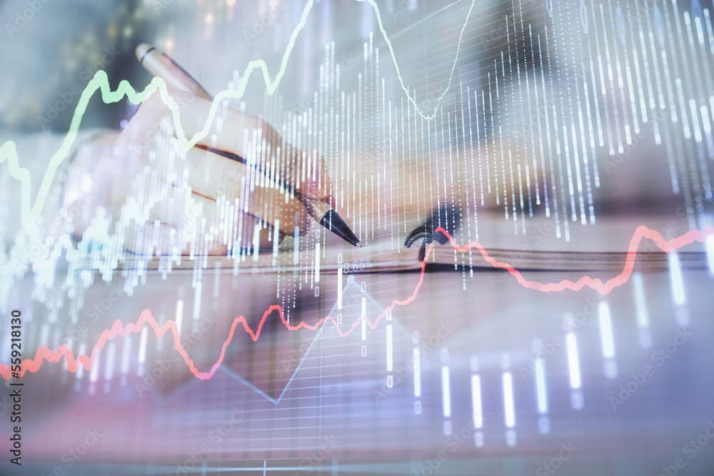 Hands writing information about stock market in notepad. Forex chart holograms in front. Concept of research. Multi exposure Hands writing information about stock market in notepad. Forex chart holograms in front. Concept of research. Multi exposure