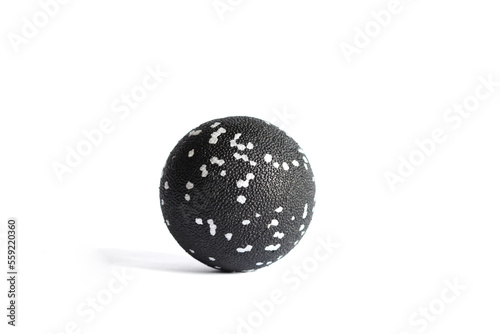 Massage black ball with white spots for trigger points isolated on a white background. Concept of myofascial release. Copy space.