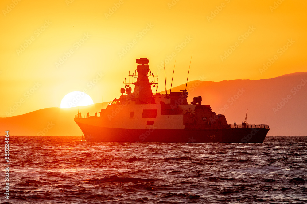 Coast guard ship flooded with sunset light in a bay of Aegean sea Coast guard ship flooded with sunset light in a bay of Aegean sea