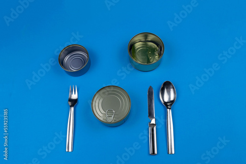 Silverware knife fork spoon napkin cans empty closed on yellow  cutlery. Nothing for dinner. What are you going to put on your plate can dish  On blue background. Nice copy space.